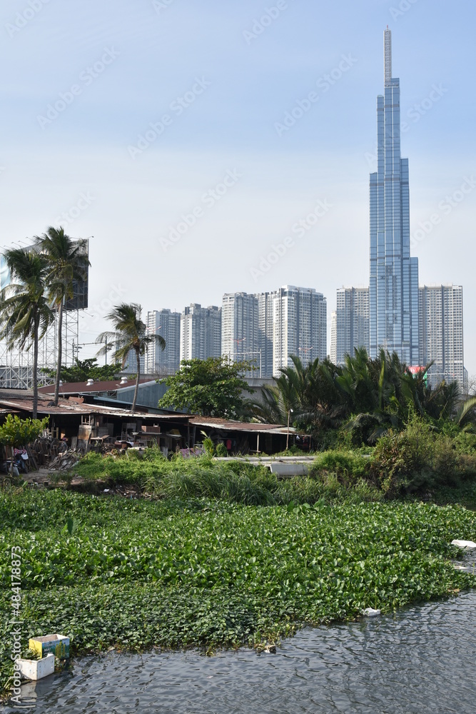 Fototapeta premium Riverside Shanties and Modern High Rise Apartments on the Saigon River