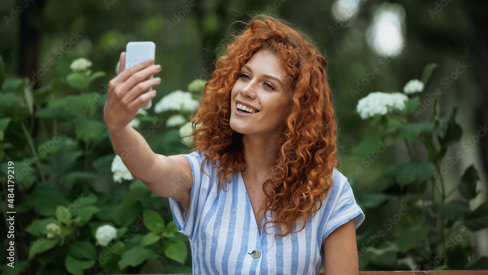happy redhead woman taking selfie in green park. happy redhead woman taking selfie in green park.