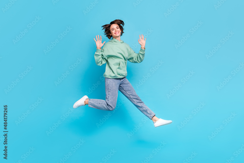 Obraz premium Full length photo of impressed millennial brunette lady jump wave wear pullover jeans sneakers isolated on blue background