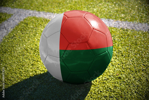football ball with the national flag of madagascar lies on the green field