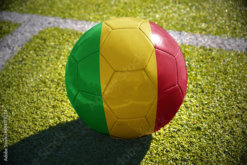 football ball with the national flag of mali lies on the green field