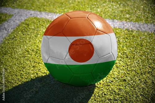 football ball with the national flag of niger lies on the green field