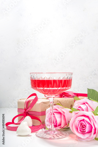 Valentines day, march 8, mother day greeting card background. Pink rose flower bouquet, craft gift box with red ribbon, rose wine cocktail on white table background copy space