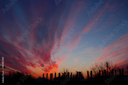 Industrial urban landscape against the background of the sky with red sunset and clouds.