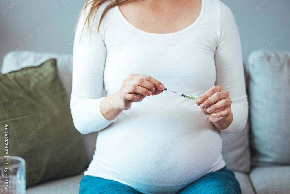 Pregnant woman injects anticoagulants into her stomach, isolated on