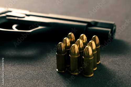 black gun and yellow bullet on black background