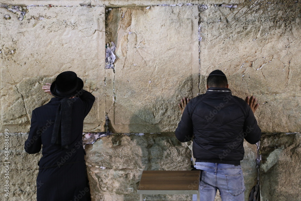 men praying at the western wall in jerusalem