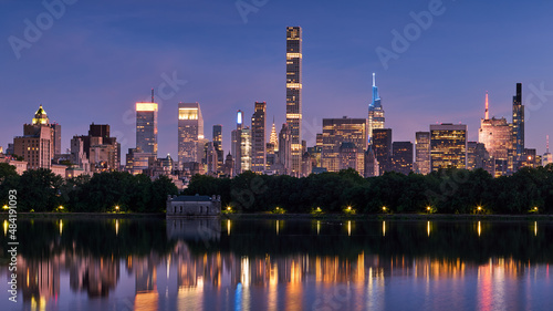 New York City skyline. Midtown Manhattan skyscrapers from Central Park Reservoir at Dusk. Evening view of illuminated luxury skyscrapers