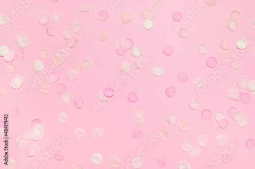 Multicolored paper confetti on pink background flat lay top view copy space. Concept of holiday, party, birthday, carnival. Festive backdrop. Pink abstract background