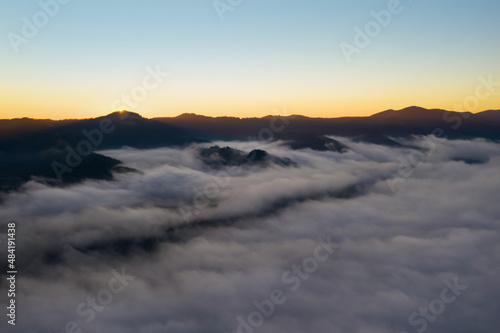 Beautiful landscape with thick mist in mountains at sunset. Drone photography