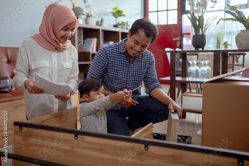 muslim family and son assembling new furniture