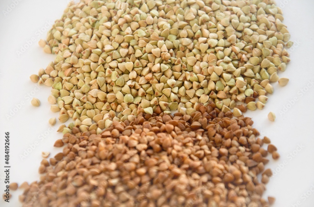 Obraz premium cereals of buckwheat and green unboiled buckwheat on a white background