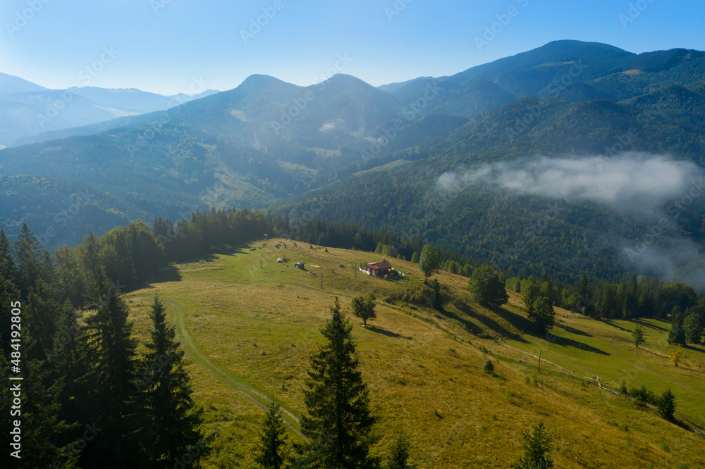 Aerial view of beautiful landscape with misty forest and village in mountains