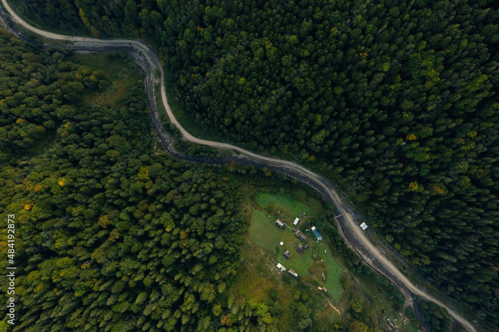 Aerial view of asphalt road surrounded by forest with beautiful green trees Aerial view of asphalt road surrounded by forest with beautiful green trees