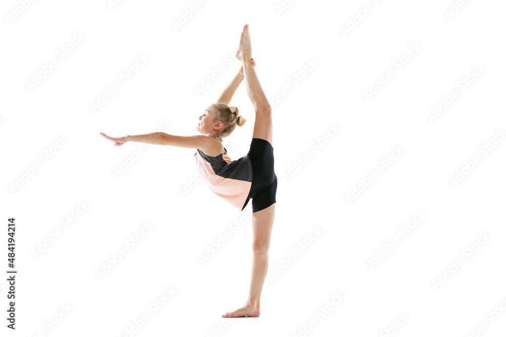 Little flexible girl, rhythmic gymnastics artist isolated on white studio background. Grace in motion, action. Doing exercises in flexibility.