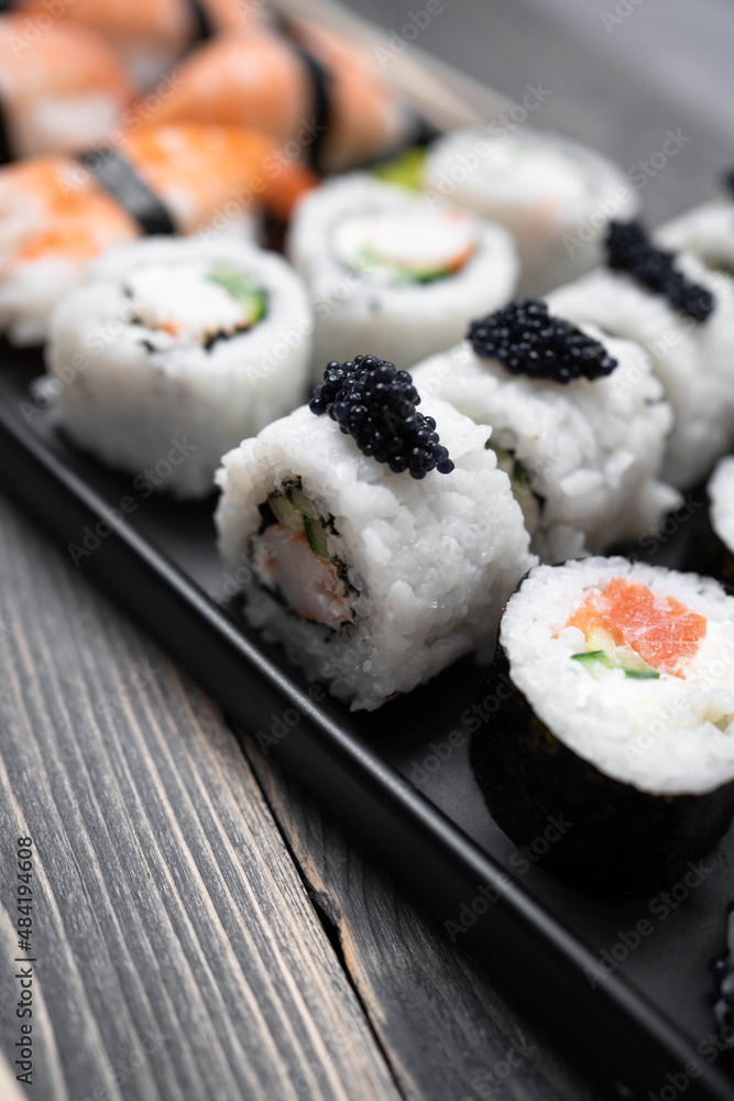Sushi with rolls on the black plate. Fresh shushi. Sushi with rolls on the black plate. Fresh shushi.