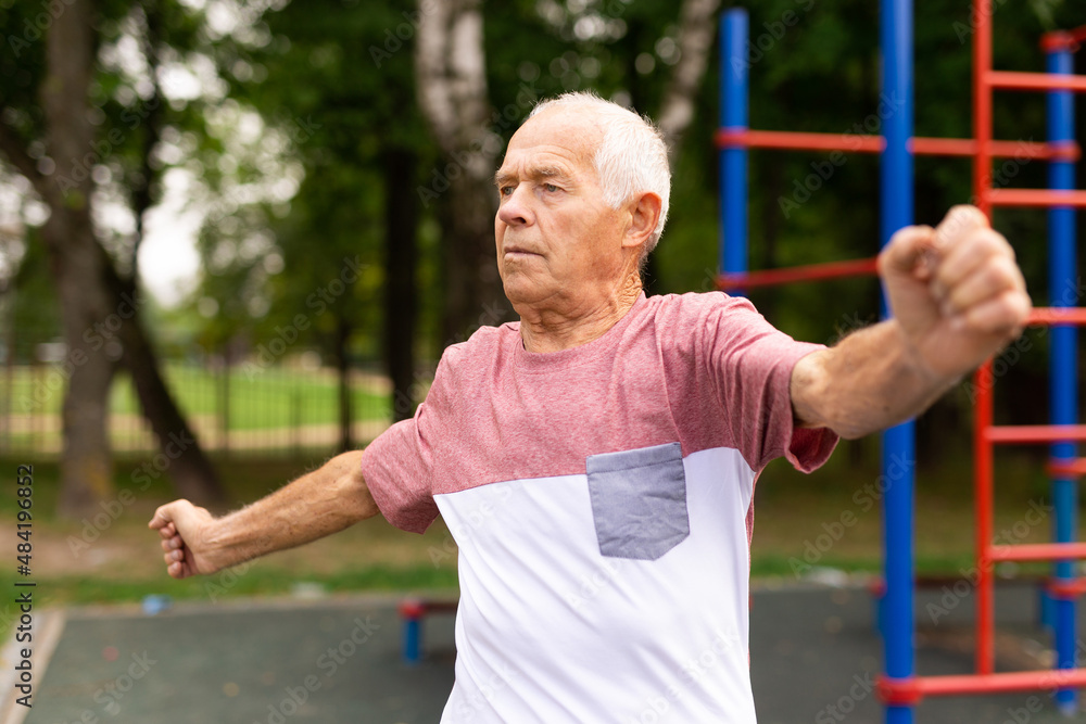 Obraz premium Old man warming up before training outdoors