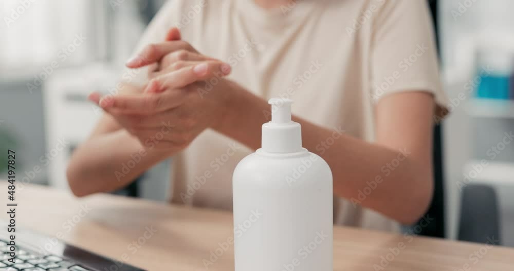 Shot of a woman's hand disinfecting her hands in the office before starting to work on the computer, hygiene care, protection against bacteria, viruses, safety in the company Shot of a woman's hand disinfecting her hands in the office before starting to work on the computer, hygiene care, protection against bacteria, viruses, safety in the company