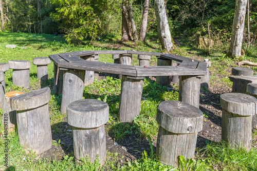 rustikaler Tisch mit Holzstüheln im Wald