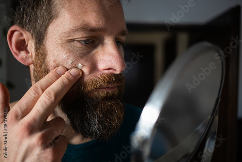 handsome Caucasian male applying face cream