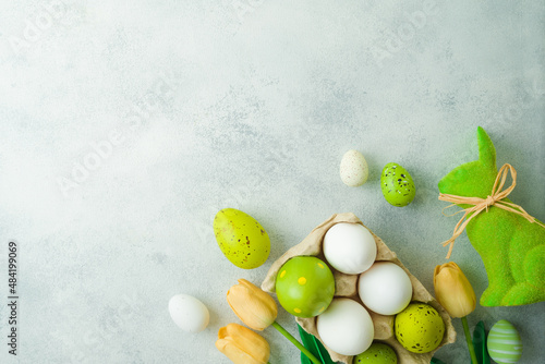 Easter holiday concept with Easter eggs and tulip flowers decor on gray background. Top view, flat lay