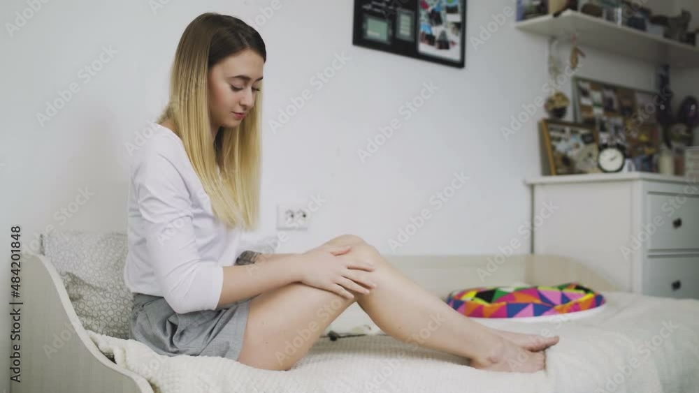 The concept of body care and beauty. The girl smears her feet with a moisturizing cream for care, so that the skin is soft and silky. The concept of body care and beauty. The girl smears her feet with a moisturizing cream for care, so that the skin is soft and silky.