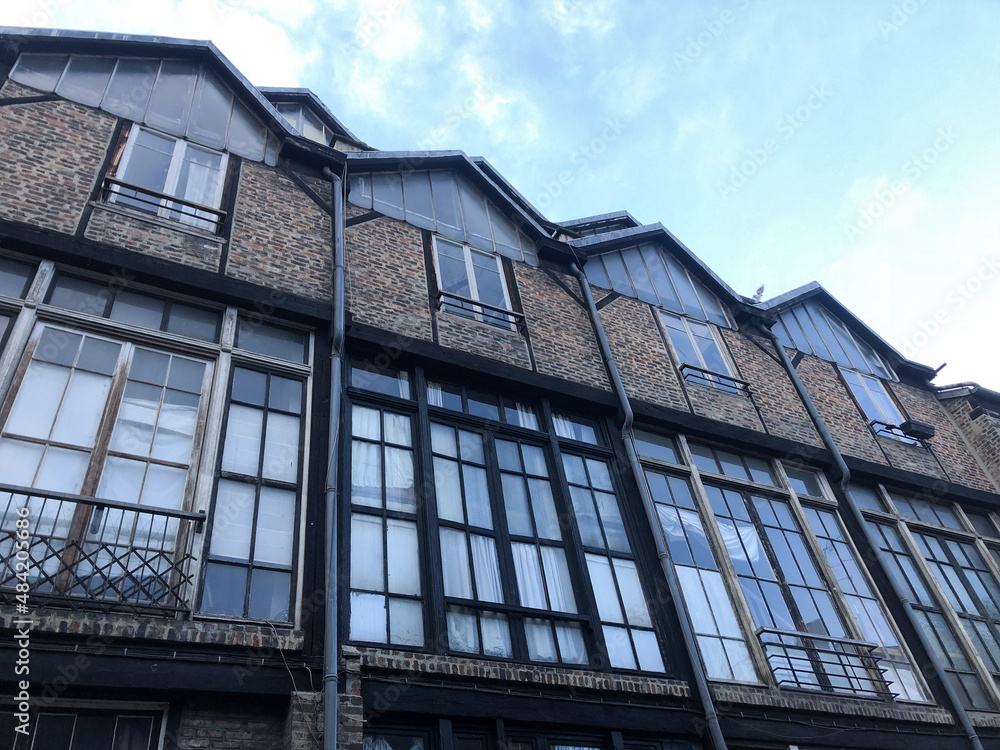 Façade d'un beau bâtiment en briques avec grandes baies vitrées et architecture type industriel. Lieu de travail.