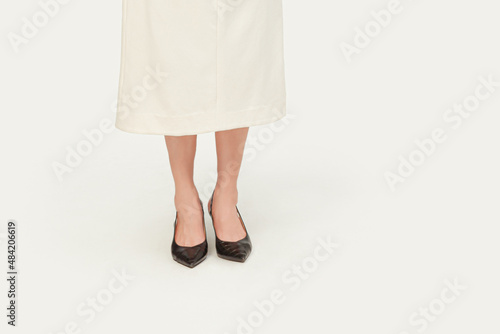 woman wear black shoes with white classic dress isolated on white background; front view