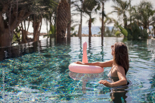 Luxury woman at beautiful pool spa relaxing in resort. © abelena