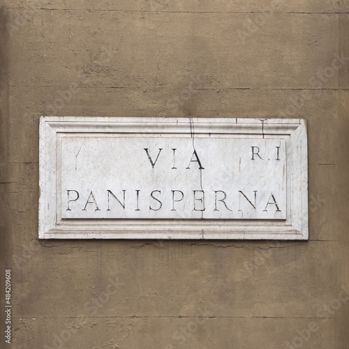 Marble street name sign in Rome on exterior wall: Via Panisterna