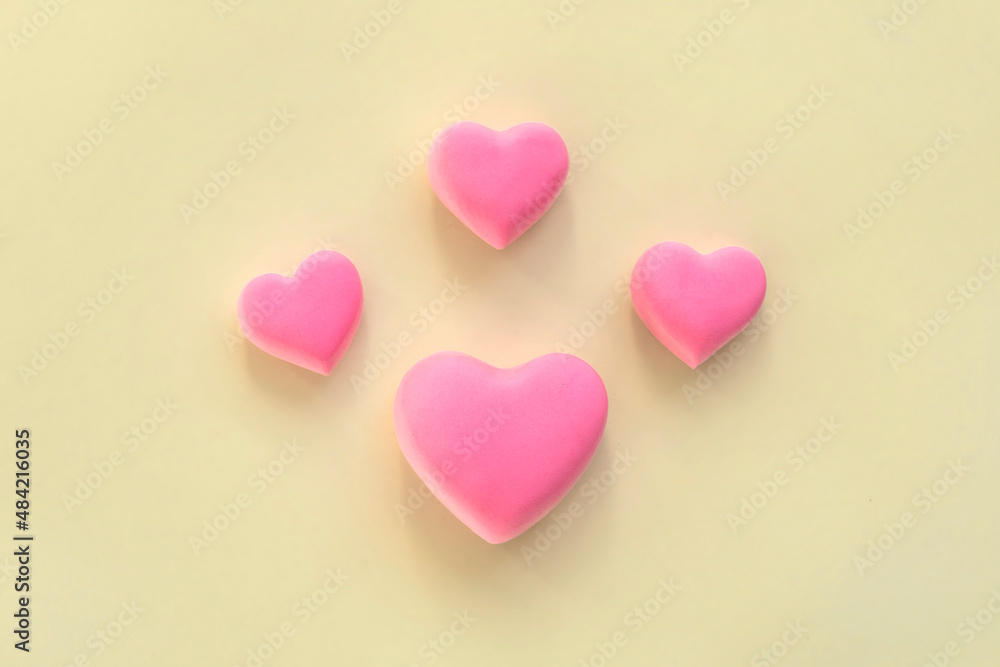 Pink hearts creative arrangement. Concept of love, romantic relationship symbol. 3d heart shape, on yellow background. Celebration of  Valentine's Day or wedding.
