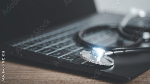 Close up of stethoscope and laptop keyboard. Digital healthcare and network on modern echnology and futuristic cure the sick online internet concept.