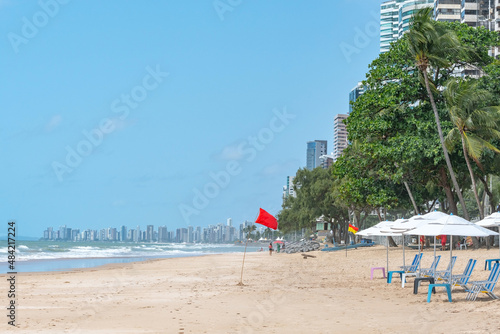 Fototapeta Naklejka Na Ścianę i Meble -  Beautiful beach with a red flag signaling danger in the water. Beach of Boa Viagem, Recife, PE, Brazil.