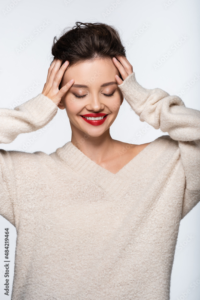 Pretty model in sweater smiling and touching head isolated on white. Pretty model in sweater smiling and touching head isolated on white.