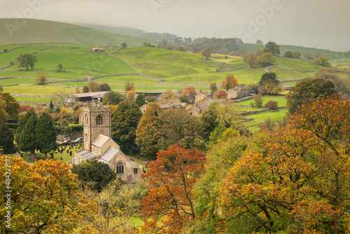 Autumn colours surround St. Wilfrid's Church in the Yorkshire Dales village of Burnsall, Wharfedale, North Yorkshire, England photo
