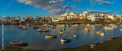 View of boats in Baha de Arrecife Marina surrounded by shops, bars and restaurants at sunset, Arrecife, Lanzarote, Canary Islands photo