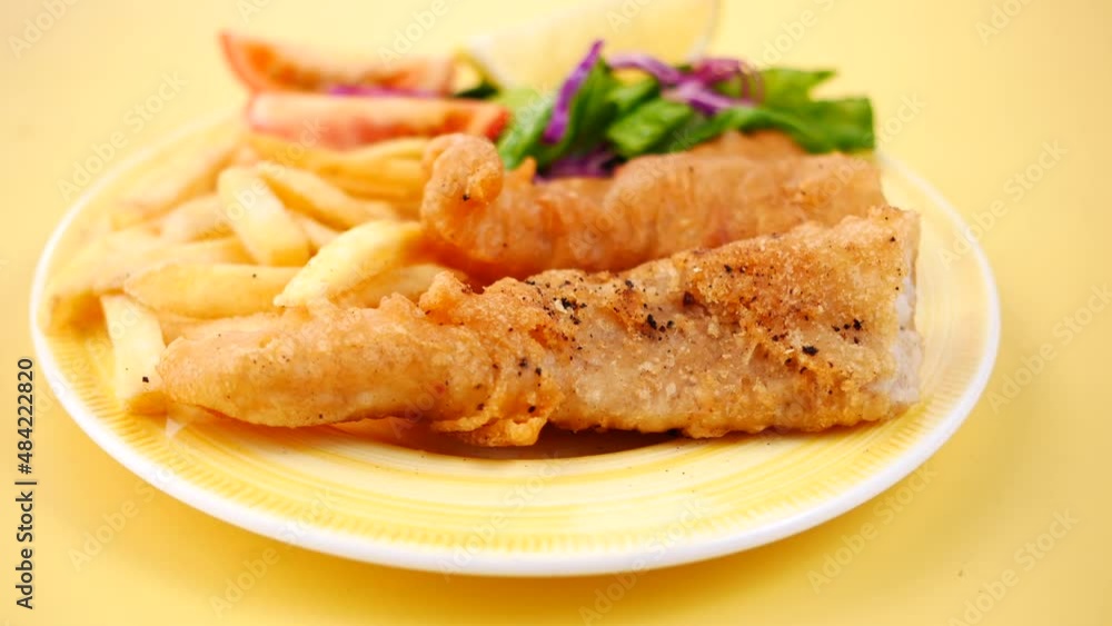 Fish fillet, lemon , chips and potato mash on table Fish fillet, lemon , chips and potato mash on table