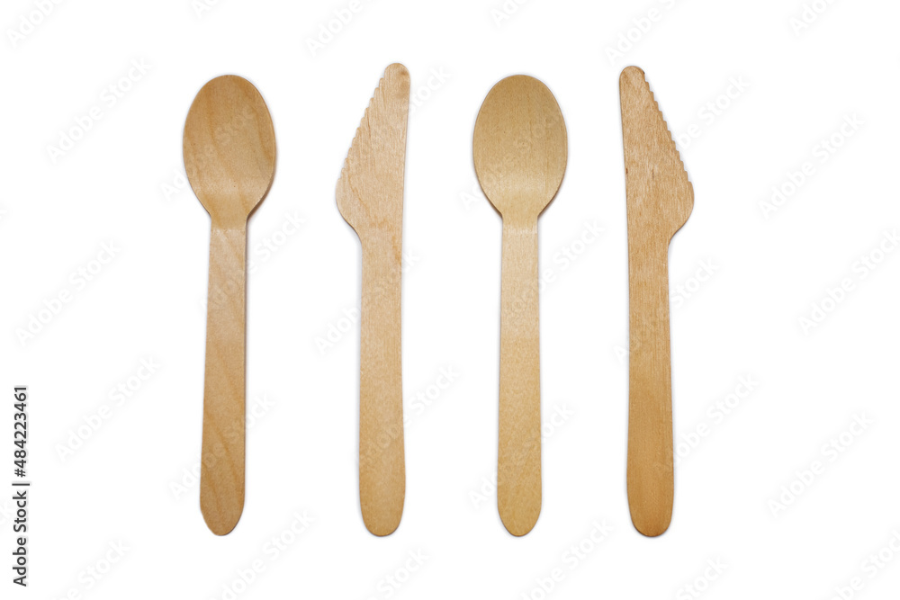Wooden spoons and knives on a white background. Eco-friendly tableware in the form of two spoons and two knives. The concept of ecological disposable tableware for eating Wooden spoons and knives on a white background. Eco-friendly tableware in the form of two spoons and two knives. The concept of ecological disposable tableware for eating