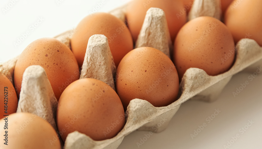 Chiken brown eggs. Organic raw eggs in cardboard boxes container.