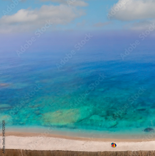 Fototapeta Naklejka Na Ścianę i Meble -  Vista desde lo alto de una pequeña playa en el mar Tirreno (Italia) de un mar turquesa de aguas transparentes. En la playa cercada por una cerca de juncos se destaca una sola sombrilla de colores.