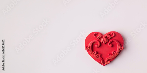 Red heart made of polymer clay on a pink background. Copy space