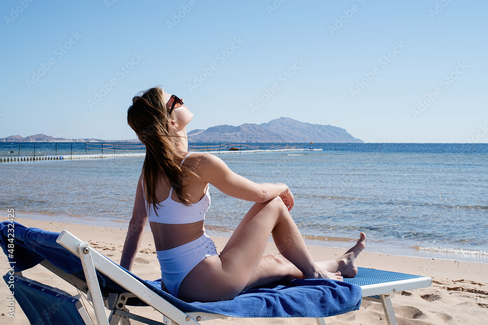 Fit sexy attractive woman lying on the beach sunbathing