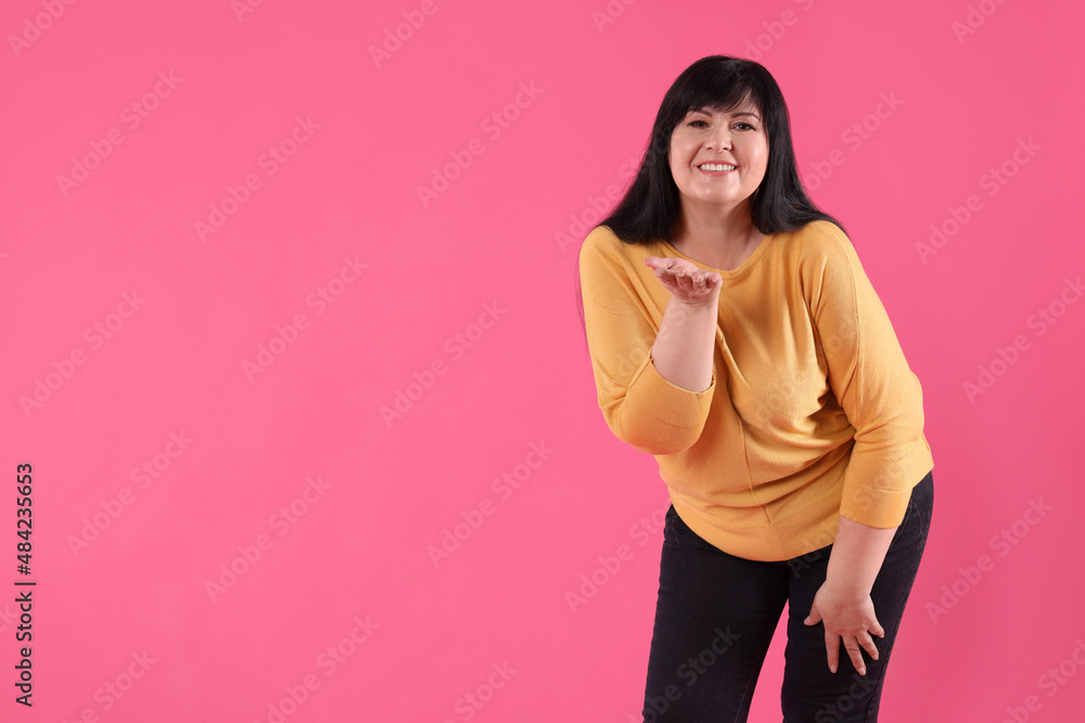 Obraz premium Beautiful overweight mature woman with charming smile on pink background. Space for text