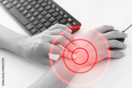 Fotografie Woman working in office with a carpal tunnel syndrome or wrist joint inflammatio