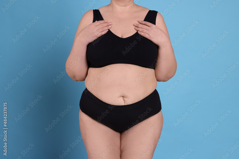Fototapeta premium Overweight woman in underwear on light blue background, closeup