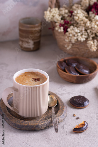 Beautiful cup of coffee on wooden table with chocolate cookies. pastel tone. Vertical