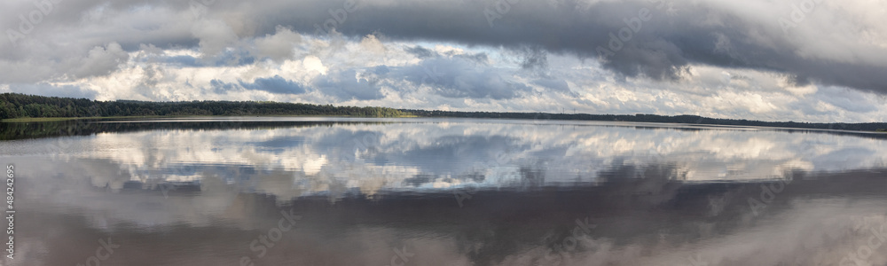 dark clouds above lake and spring forest dark clouds above lake and spring forest