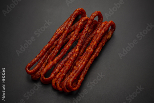 Cabanossi, dry sausage isolated on black background. photo