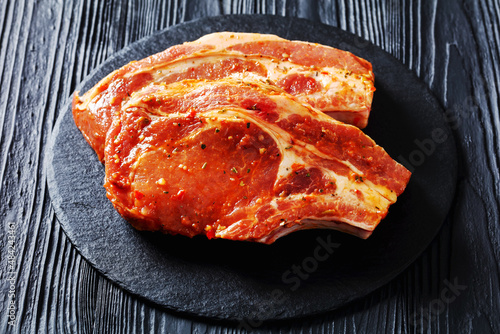 raw marinated pork chops on a plate