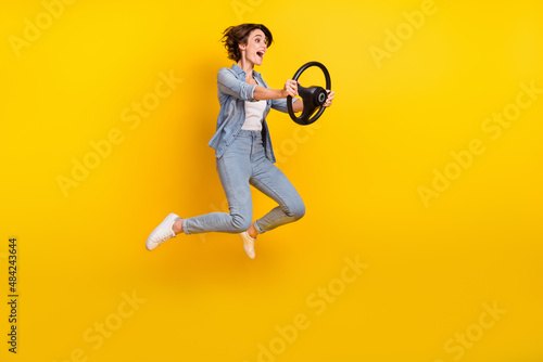 Full body photo of young lady jumper look empty space vehicle rider isolated over yellow color background © deagreez